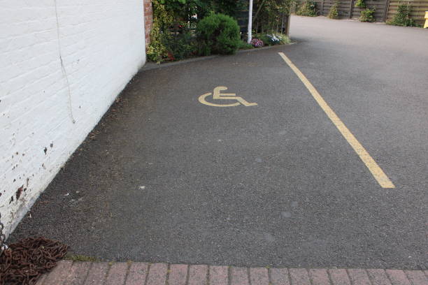 istock Disabled parking bay yellow disabled symbol with painted line UK 1732224613