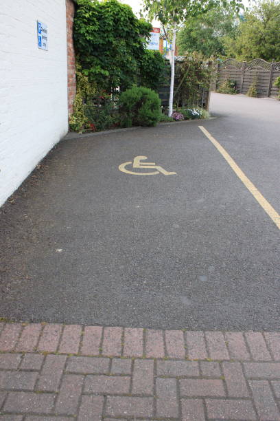 istock Disabled parking bay yellow disabled symbol with painted line UK 1732225160