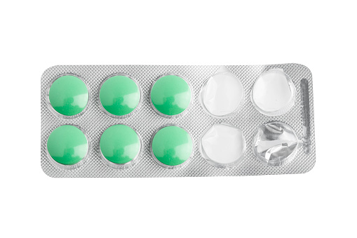 Green tablets in a blister pack. Opened packaging. isolated on white background