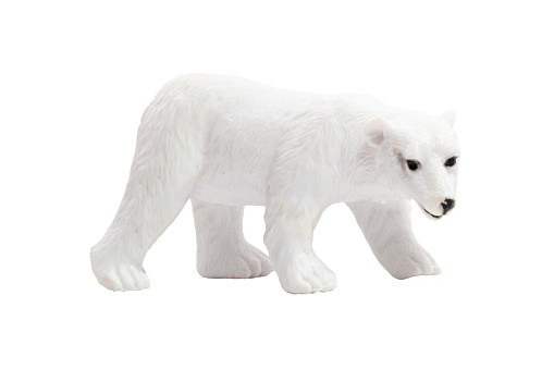 An isolated toy polar bear walking on all fours in profile on a white background. Wild animals concept.