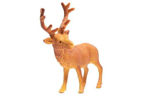 A plastic orange deer toy isolated on a white background. Wild animals concept.