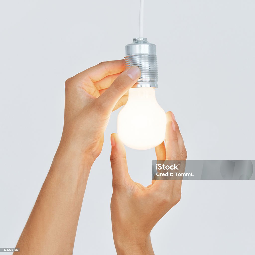 Changing Light Bulb Hands of a person changing a light bulb. Light Bulb Stock Photo