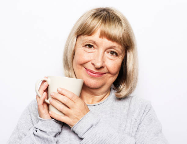 istock Old excited lady smiling laughing, holding cup drinking coffee, tea, beverage on white background 1732313779