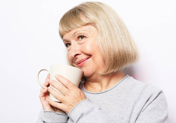 istock Old excited lady smiling laughing, holding cup drinking coffee, tea, beverage on white background 1732313793