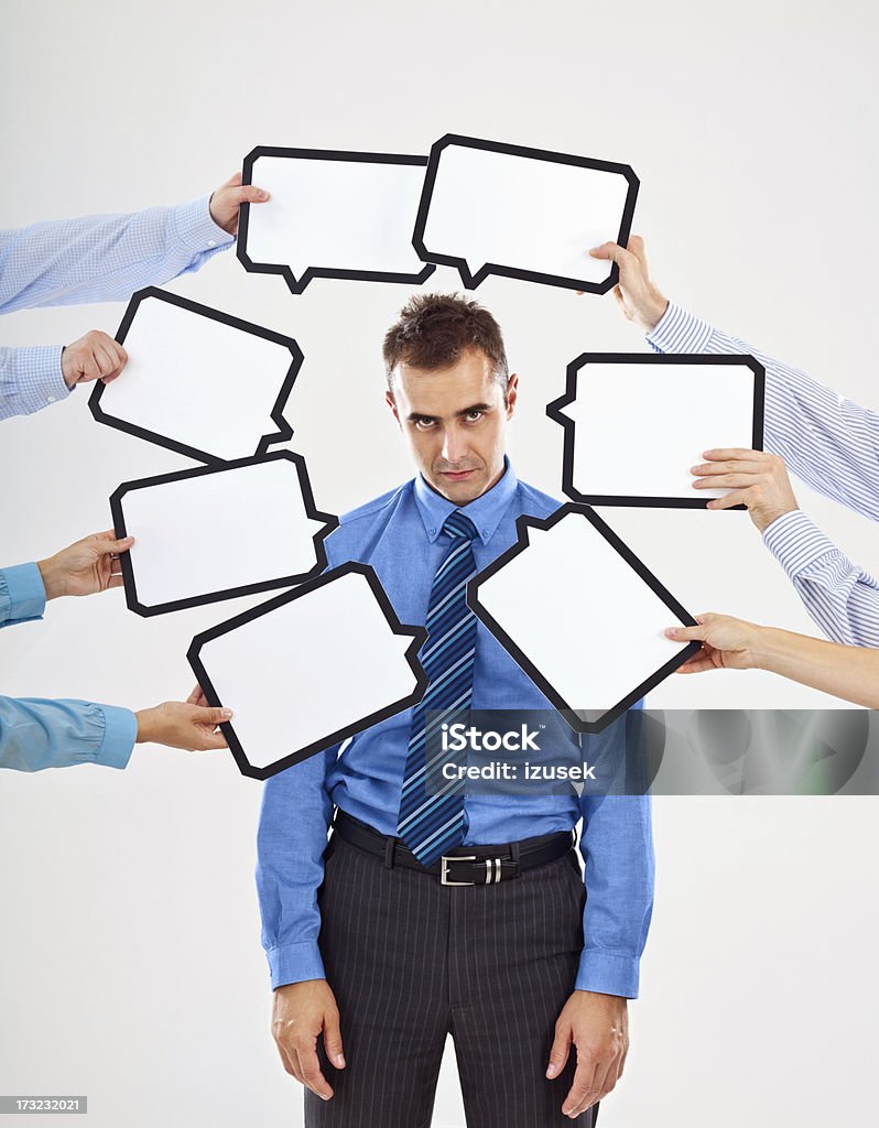 Attacked by thoughts Portrait of exhausted businessman surrounded by many speech bubbles with copyspace, looking at the camera. 30-34 Years Stock Photo