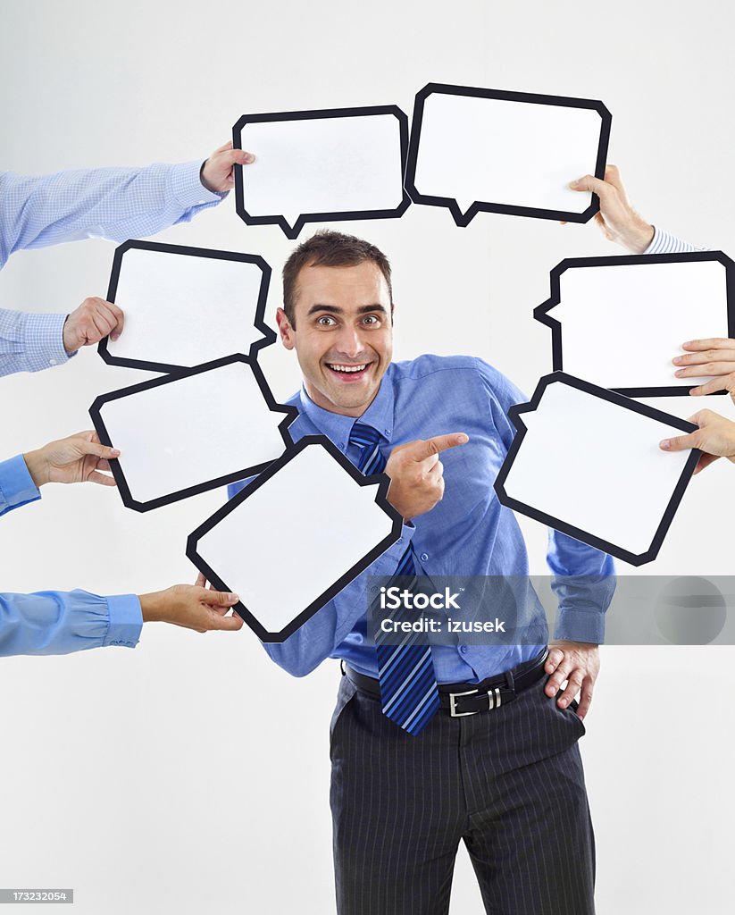 My choice Portrait of happy businessman surrounded by many speech bubbles with copyspace and pointing at one of them. Smiling at the camera. 30-34 Years Stock Photo