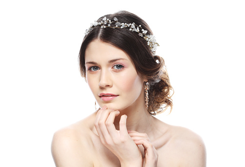 Jewelry, luxury, wedding and people concept: young bride with gorgeous diadem in her hair over white background