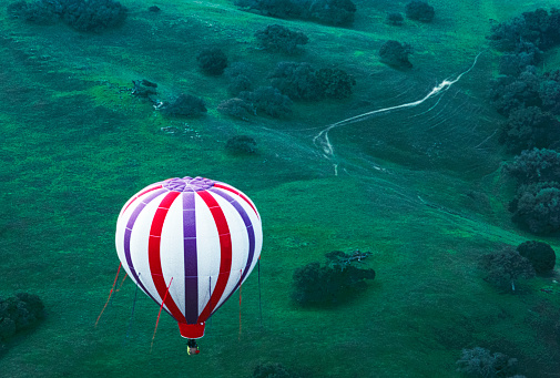 High angle view of hot air balloon in flight through Carmel Valley\n\nTaken over Carmel Valley, California, USA.