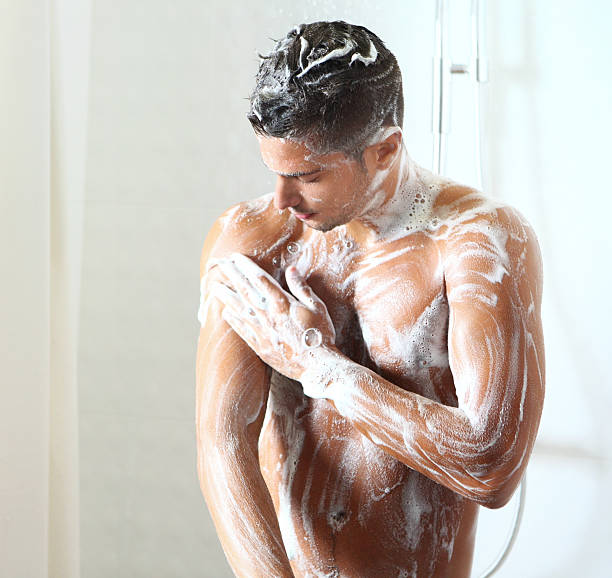 若い男性たシャワーを備えております。 - men naked shower bathroom ストックフォトと画像