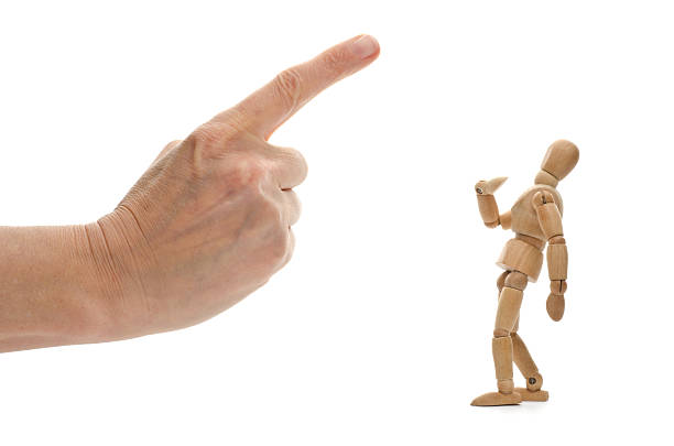 istock Small wooden mannequin and human hand with pointed finger 173234021