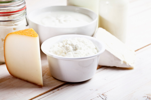dairy products such as cheese, yoghurt, cottage cheese, milk in a glass bottle on wooden table