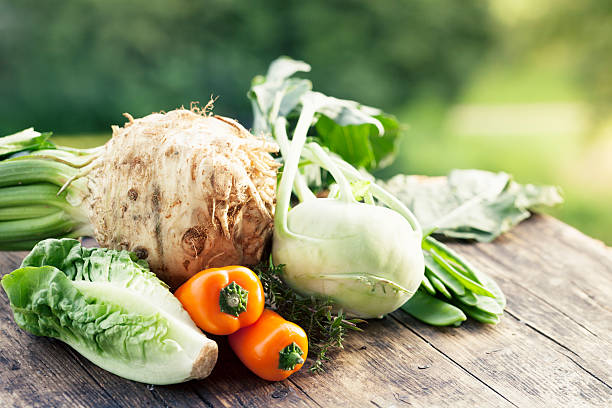 mix of cabbage, lettuce and turnips in a wooden crate on a white background