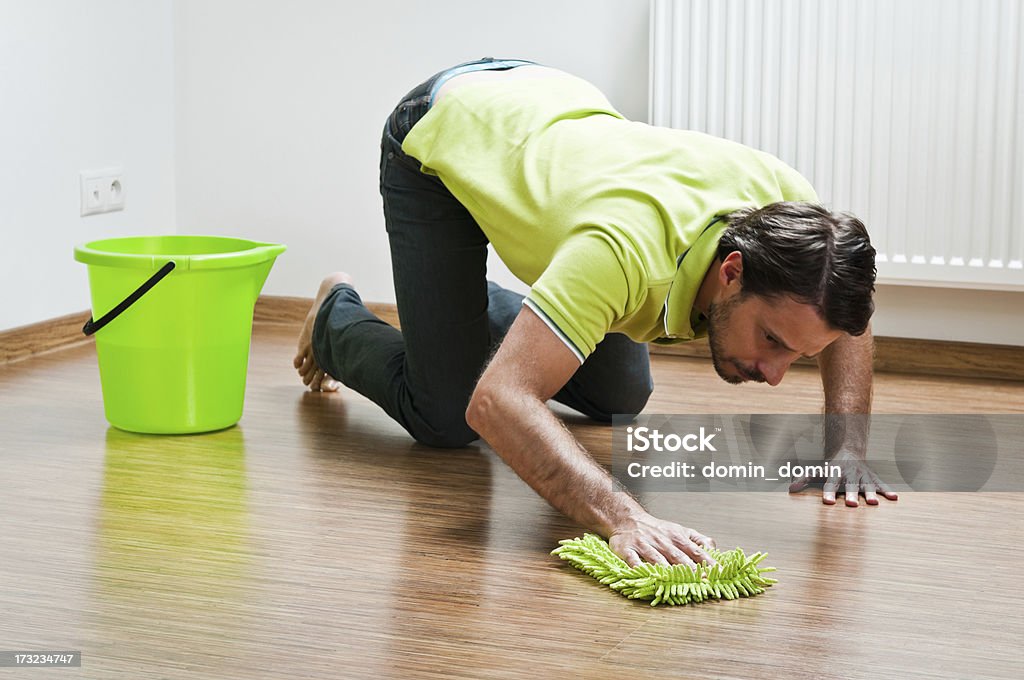 Junger Mann macht houseworks, Mann Polieren der Etage - Lizenzfrei Boden Stock-Foto