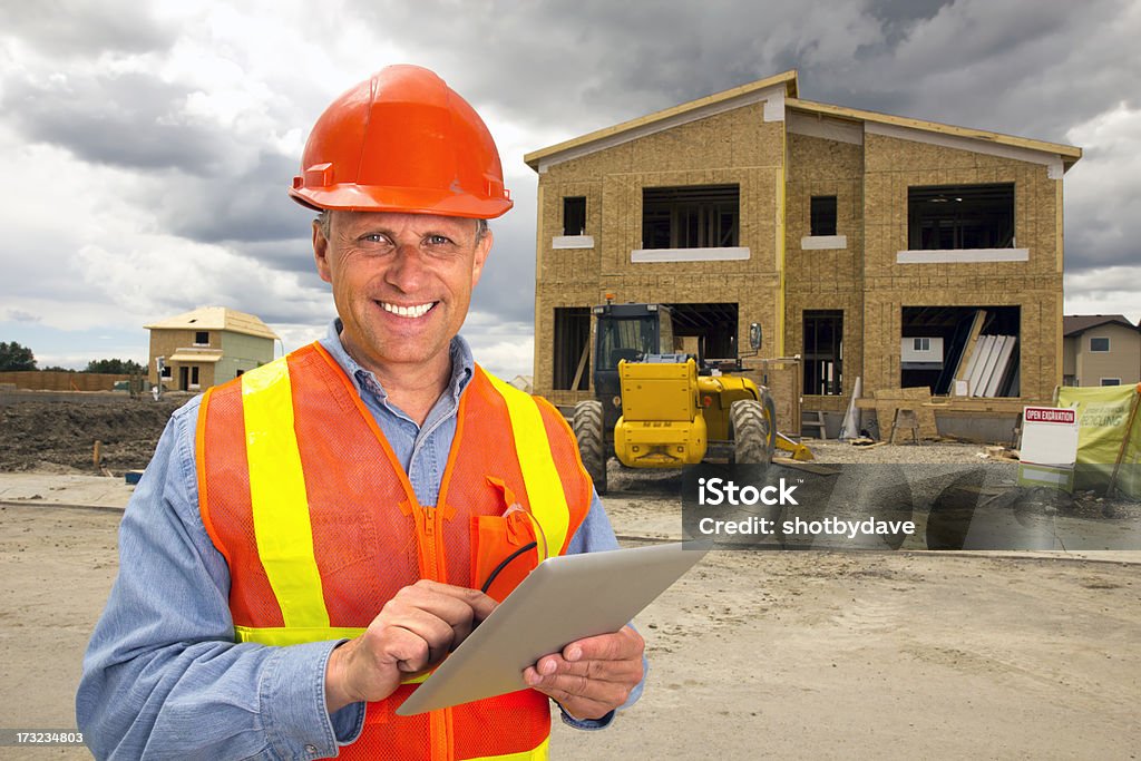 Housing Development and Computer A royalty free image from the construction industry of a building contractor using a tablet computer at a new housing development. Construction Industry Stock Photo