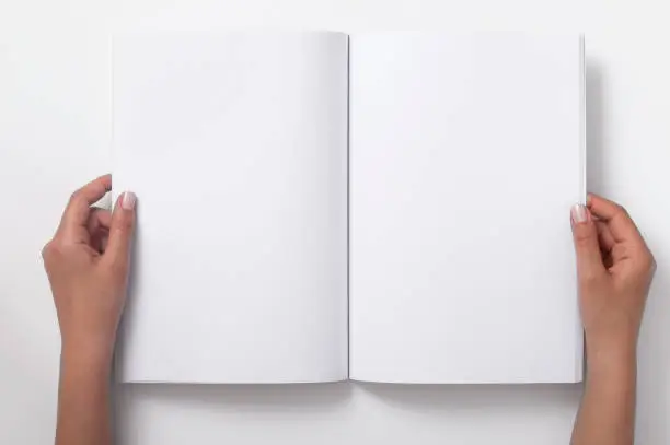 Two Female Hands Holding Open A Blank Magazine