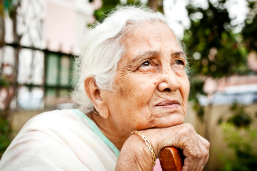 Un triste pensativo India senior mujer mirando hacia arriba photo
