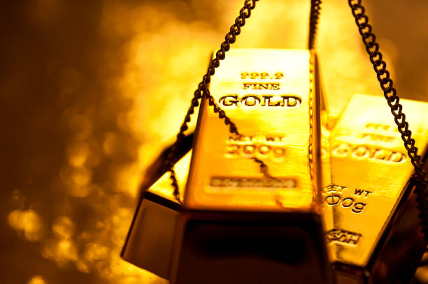 Gold ingot on weight scale stock photo