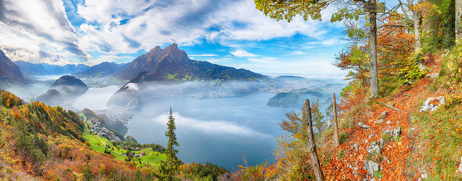 Fabulous autumn view of Stansstad city and Lucerne lake with mountaines and fog. Poppular travel destination in Swiss Alps.   Location: Stansstad, Canton of Nidwalden, Switzerland, Europe