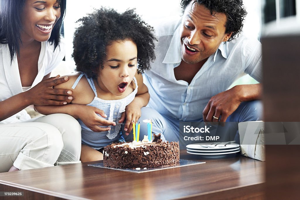 Adorável menina comemorando seu aniversário com os pais - Foto de stock de 30 Anos royalty-free