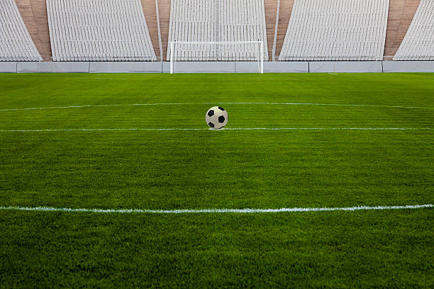 サッカーボールをセンタースポット - soccer man made material goal post grass ストックフォトと画像