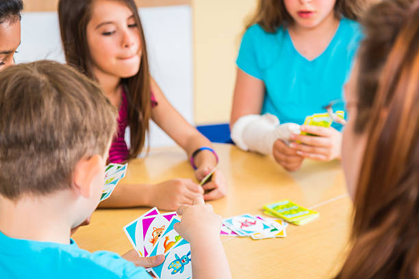 istock Teacher and school children playing card game 173240395