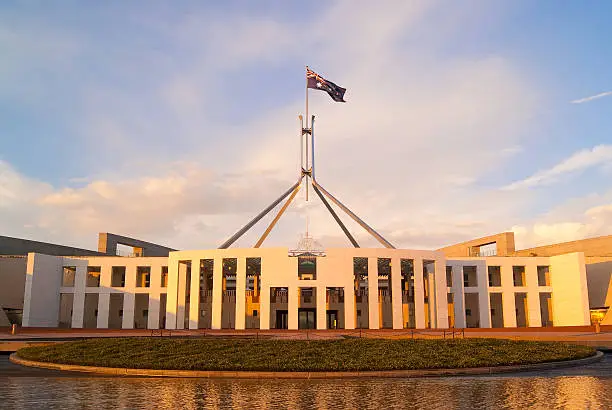 The rising sun casts a golden sheen on Parliament House in Canberra, Australia.