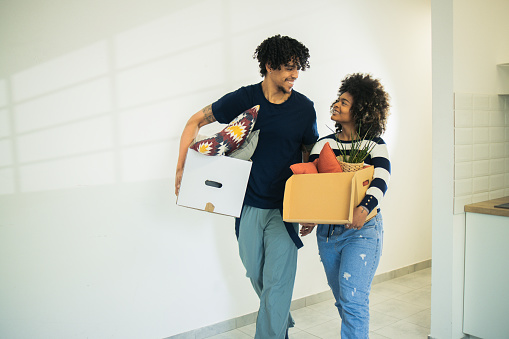 Mixed race couple moving into a new home, bringing their belongings