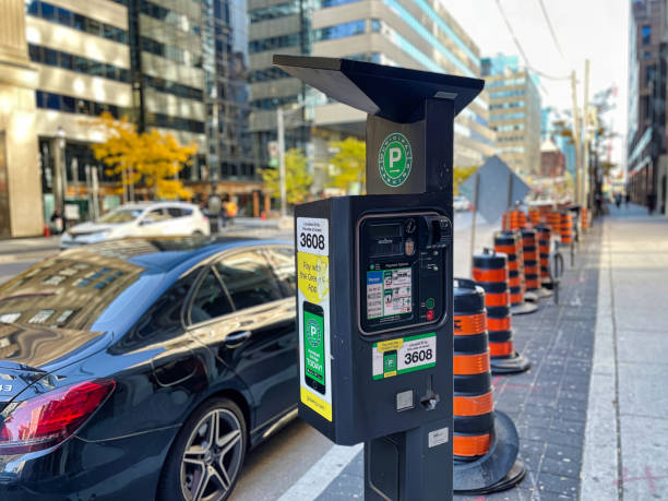 parking meter on sidewalk of Toronto city shopping street Toronto, Canada - 24 October 2022: a parking meter has been placed on the sidewalk of a street downtown with shops and store around sustainable energy toronto stock pictures, royalty-free photos & images