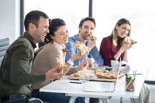 istock Colleagues having lunch break together in the office. 1732417530