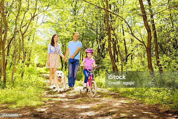 Familia Con Los Niños A Y Ciclismo En Un Bosque Foto de stock y más banco de imágenes de Perro - Perro, Camino, Familia