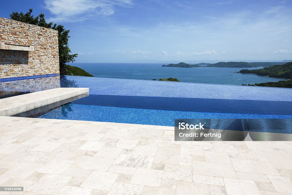 Patio i basenem infinity z widokiem na horyzont ponad-widokiem na ocean - Zbiór zdjęć royalty-free (Basen)