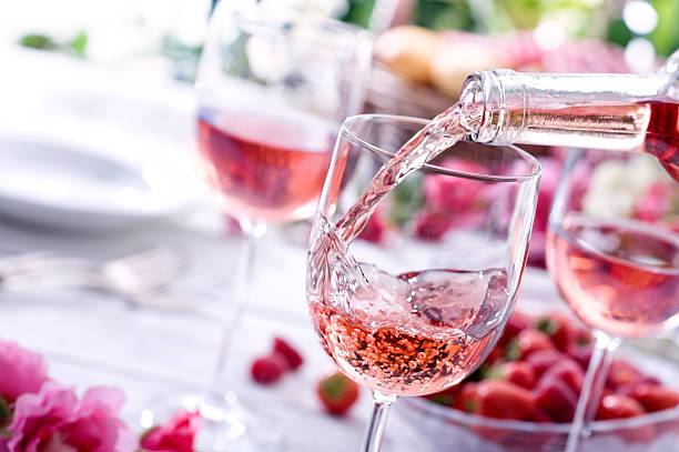 Rose Wine at Picnic Close up of Rose wine being poured at a picnic setting. rose wine stock pictures, royalty-free photos & images