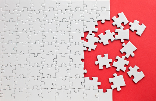 White details of jigsaw puzzle piece on wooden background. Concept of working together as a business team. The idea of getting involved, working for success.