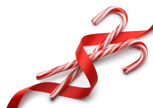 Candy canes with red ribbon on white with soft shadow.