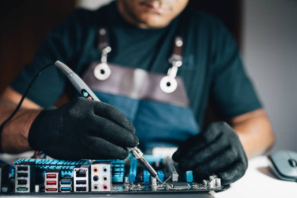 istock Technician soldering a computer mother board in his repair shop 1732447369