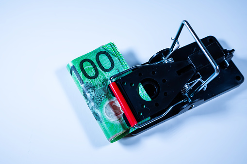 One hundred dollars australian banknote in the mousetrap isolated on white background.