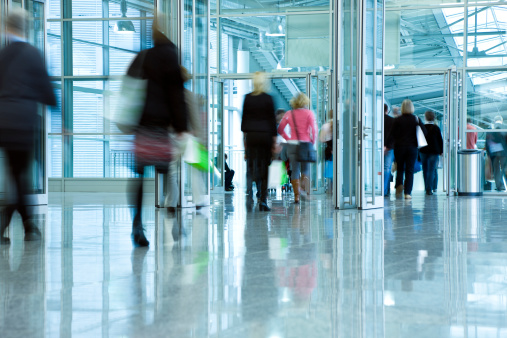 people walking through the doors in a modern building, motion blur