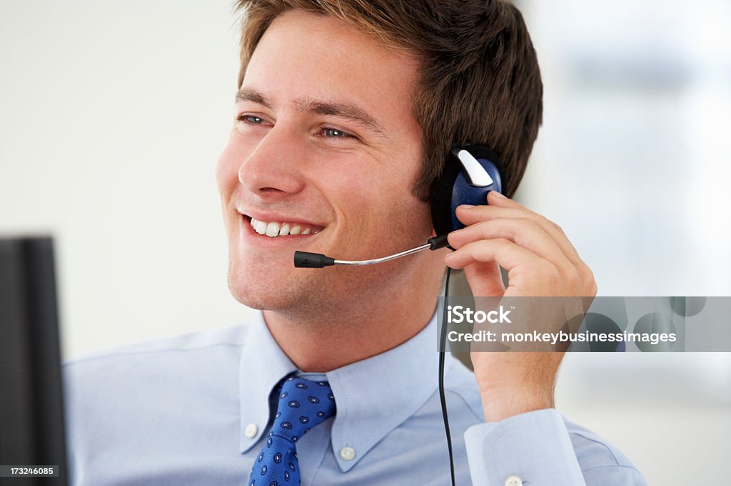 Sonriente hombre call center agent hablando con el cliente - Foto de stock de 20 a 29 años libre de derechos