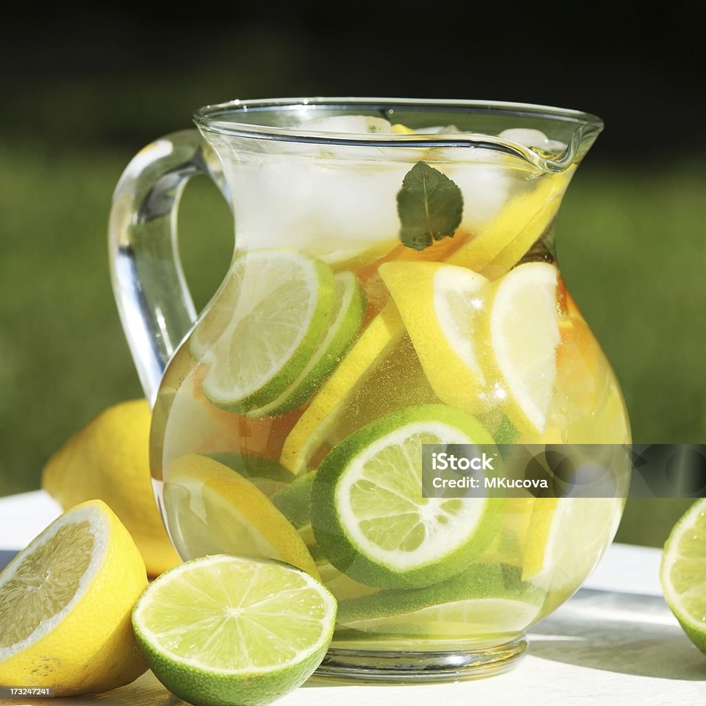 Fruit lemonade Jug with fresh lemonade and fruits. Summer day in the garden. Arrangement Stock Photo