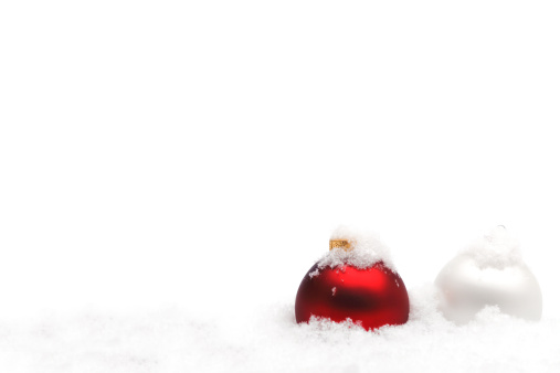 Decorative red Christmas balls covered in snowflakes with a white background with copy space. Suitable as Christmas card background.