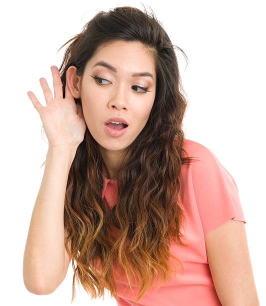 Young Woman Listening With Hand To Ear Portrait of a young woman on a white background. http://s3.amazonaws.com/drbimages/m/an.jpg eavesdropping stock pictures, royalty-free photos & images