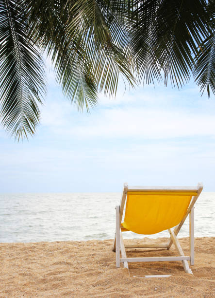 chaise de plage sur la plage de sable blanc et le cocotier avec un ciel bleu nuageux - beach tropical climate palm tree deck chair photos et images de collection
