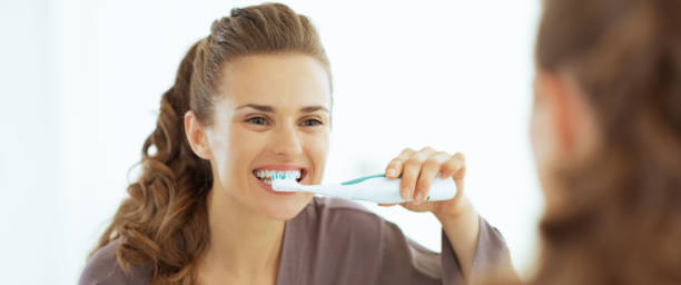 istock Young woman brushing teeth in bathroom 1732521545
