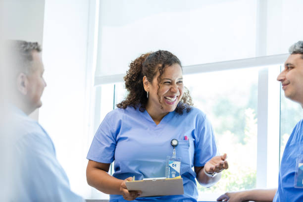 istock Female nurse laughs while talking with her colleagues 1732521763