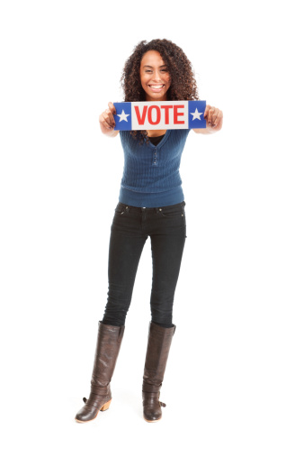 Subject: Young smiling happy woman holding VOTE sign, isolated on white background