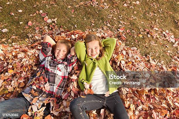 Niños Relajarse Y Descansar En La Pila De Hojas De Otoño Hz Foto de stock y más banco de imágenes de Hoja