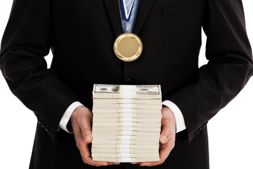 Businessman holding large stack of money and wearing a gold medal