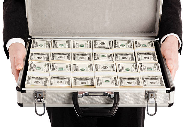 Businessman holding briefcase with money