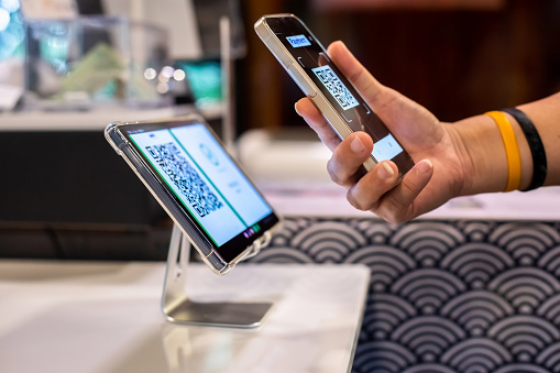 Selective focus to Smartphone in hand to scan simulate QR code payment tag in restaurant to accepted generate digital pay without money. Qr code payment concept.
