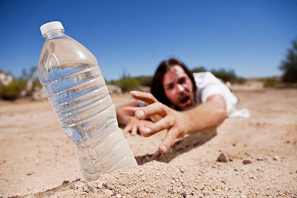 man in desert alcanzar para agua - sediento fotografías e imágenes de stock